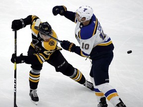 Boston Bruins left wing Peter Cehlarik (22) and St. Louis Blues center Brayden Schenn (10) compete for the puck during the first period of an NHL hockey game Thursday, Jan. 17, 2019, in Boston.