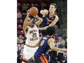 Boston College guard Jordan Chatman (25) passes the ball away from Virginia guards Kyle Guy (5) and guard Kihei Clark (0) during the first half of an NCAA basketball game Wednesday, Jan. 9, 2019, in Boston.