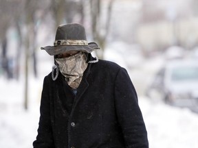 Marvin Hooks wears a face mask to protect him from the cold as he walks on North Street in Pittsfield, Mass., Monday, Jan. 21, 2019. Bitter cold and gusty winds swept across the eastern U.S. Monday with falling temperatures replacing the weekend's falling snow.