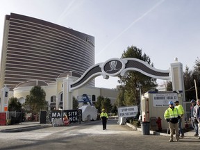 In this Wednesday, Jan. 2, 2019 photo workers stand near an entrance to the under-construction Encore Boston Harbor luxury resort and casino, in Everett, Mass. A Nevada judge was being asked Friday, Jan. 4 to let the Massachusetts Gaming Commission make public a report on allegations of sexual misconduct against former casino mogul Steve Wynn. A decision could affect a decision on a pending license for the $2 billion casino and hotel being built in Everett.