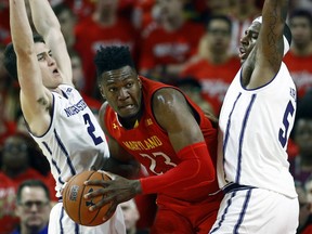 Maryland forward Bruno Fernando, center, of Angola, drives between Northwestern guard Ryan Greer, left, and center Dererk Pardon in the first half of an NCAA college basketball game, Tuesday, Jan. 29, 2019, in College Park, Md.