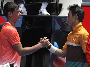 Poland's Kamil Majchrzak, left, congratulates Japan's Kei Nishikori after retiring injured in their first round match at the Australian Open tennis championships in Melbourne, Australia, Tuesday, Jan. 15, 2019.