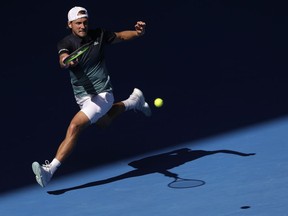 France's Lucas Pouille makes a forehand return to Canada's Milos Raonic during their quarterfinal match at the Australian Open tennis championships in Melbourne, Australia, Wednesday, Jan. 23, 2019.