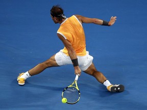 Spain's Rafael Nadal makes a backhand return to Australia's Alex de Minaur during their third round match at the Australian Open tennis championships in Melbourne, Australia, Friday, Jan. 18, 2019.