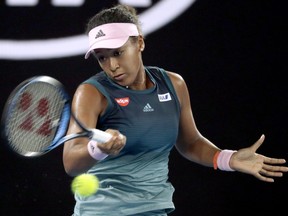 Japan's Naomi Osaka makes a forehand return to Poland's Magda Linette during their first round match at the Australian Open tennis championships in Melbourne, Australia, Tuesday, Jan. 15, 2019.