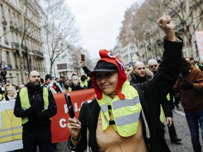 A yellow vest protester donning a red bonnet , that symbolizes the French Revolution during a march in Paris, Saturday, Jan. 5, 2019. Hundreds of protesters were trying to breathe new life into France's apparently waning yellow vest movement with marches in Paris and gatherings in other cities.