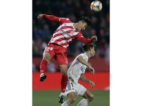 Real Madrid's Marcos Llorente, right, duels for the ball with Girona's Paik Seung-ho during a Spanish Copa del Rey soccer match between Girona and Real Madrid at the Montilivi stadium in Girona, Spain, Thursday, Jan. 31, 2019.