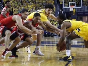 Michigan guard Zavier Simpson, right, steals the ball away from Ohio State forward Jaedon LeDee, center left, during the first half of an NCAA college basketball game Tuesday, Jan. 29, 2019, in Ann Arbor, Mich.