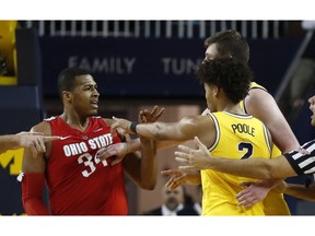 Michigan center Jon Teske pushes away Ohio State forward Kale Wesson while guard Jordan Poole (2) gestures during the second half of an NCAA college basketball game Tuesday, Jan. 29, 2019, in Ann Arbor, Mich.