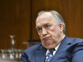 FILE - In this Feb. 16, 2018 file photo, Michigan State University interim President John Engler listens as he runs his first Michigan State University Board of Trustees meeting on campus in East Lansing, Mich. Engler will resign as interim president of Michigan State University amid public backlash over his comments about women and girls sexually assaulted by now-imprisoned campus sports doctor Larry Nassar, a member of the school's Board of Trustees said Wednesday, Jan. 16, 2019.