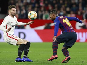 Sevilla's Sergi Gomez, left, fight for the ball with FC Barcelona's Malcom, during a Spanish Copa del Rey soccer match between Sevilla and FC Barcelona at the Ramon Sanche Pizjuan stadium in Seville, Spain, Wednesday Jan. 23, 2019.