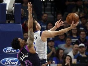 Dallas Mavericks' J.J. Barea, right, prepares to lay up as Minnesota Timberwolves' Jeff Teague defends in the first half of an NBA basketball game Friday, Jan. 11, 2019, in Minneapolis.