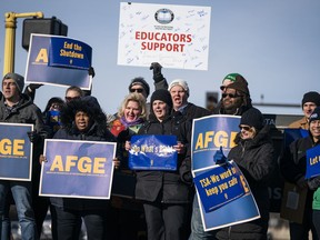 Government workers, American Federation of Government Employees union members and members of supporting local unions, pose for a group photo during the rally to highlight the effect the federal shutdown, Thursday, Jan. 10, 2019, in Minneapolis.
