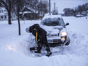 Adam Fischer shovels out his vehicle to go to work Monday, Jan. 28, 2019, in Rochester, Minn. Heavy snow and gusting winds created blizzard-like conditions Monday across parts of the Midwest, prompting officials to close hundreds of schools, courthouses and businesses, and ground air travel.