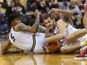 Missouri's Reed Nikko, center, holds on to the ball between teammate Mitchell Smith, left, and Alabama's Avery Johnson Jr., right, during the first half of an NCAA college basketball game, Wednesday, Jan. 16, 2019, in Columbia, Mo.
