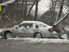 Michael Fuehne, left, and David Fellner Jr., both of Belleville, strain as they push the car of Billy Brownlee out of a pile of snow after Brownlee went sideways while making a turn in Belleville, Ill., on Saturday,  Jan. 12, 2019. Multiple deaths on snow-slicked roads were reported in the Midwest as a winter storm swept the region this weekend, snarling traffic in several states and leaving thousands without power.