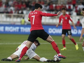 China's defender Zheng Zhi, ground, and South Korea's forward Son Heung-Min fight for the ball during the AFC Asian Cup group C soccer match between South Korea and China at Al Nahyan Stadium in Abu Dhabi, United Arab Emirates, Wednesday, Jan. 16, 2019.