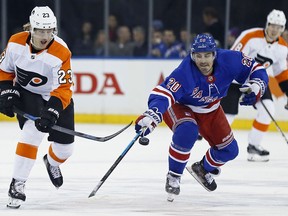 Philadelphia Flyers left wing Oskar Lindblom (23) passes the puck past New York Rangers left wing Chris Kreider (20) in the first period of an NHL hockey game Tuesday, Jan. 29, 2019, in New York.