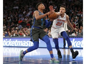 New York Knicks forward Kevin Knox (20) defends Dallas Mavericks guard Dennis Smith Jr. (1) during the first half of an NBA basketball game Wednesday, Jan. 30, 2019, in New York.