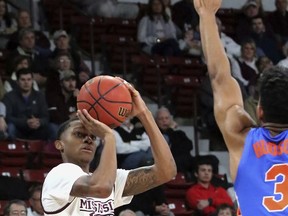 Mississippi State guard Tyson Carter (23) shoots over the outstretched arm of Florida guard Jalen Hudson (3) during the first half of an NCAA college basketball game Tuesday, Jan. 15, 2019, in Starkville, Miss.