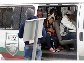 A migrant family waits with others before being transported by Mexican authorities to the San Ysidro port of entry to begin the process of applying for asylum in the United States, in Tijuana, Mexico, Tuesday, Jan. 29, 2019. The head of Mexico's immigration agency said Monday that his country won't accept migrants younger than 18 while they await the resolution of their U.S. asylum claims.