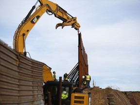 Workers replace sections of the border wall, left, with new sections, right, Tuesday, Jan. 8, 2019, in Tijuana, Mexico. Ready to make his case on prime-time TV, President Donald Trump is stressing humanitarian as well as security concerns at the U.S.-Mexico border as he tries to convince America he must get funding for his long-promised border wall before ending a partial government shutdown that has hundreds of thousands of federal workers facing missed paychecks.