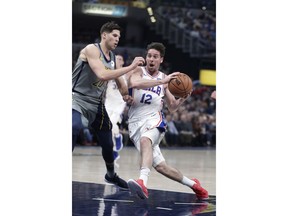 Philadelphia 76ers guard T.J. McConnell (12) drives on Indiana Pacers forward Doug McDermott (20) during the first half of an NBA basketball game in Indianapolis, Thursday, Jan. 17, 2019.