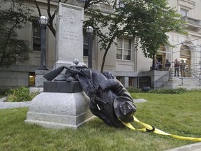 FILE - In this Aug. 14, 2017, file photo, a toppled Confederate statue lies on the ground in Durham, N.C. A North Carolina city will unveil a proposal for the fate of a Confederate monument toppled by protesters in 2017. Durham's city and county government will hear recommendations Tuesday, Jan. 8, 2019, about what to do with the statue of an anonymous soldier that stood in front of the old county courthouse.