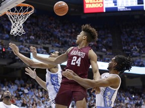 North Carolina's Garrison Brooks, left, and Coby White defend against Harvard's Kale Catchings (24) during the second half of an NCAA college basketball game in Chapel Hill, N.C., Wednesday, Jan. 2, 2019. North Carolina won 77-57.