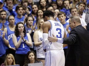 Duke's Tre Jones (3) is escorted from the court following an injury during the first half of an NCAA college basketball game against Syracuse in Durham, N.C., Monday, Jan. 14, 2019. No. 1-for-now Duke will have to figure out how to play without perhaps its most irreplaceable player now that point guard Tre Jones is out indefinitely with a shoulder injury.