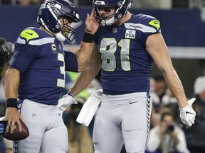 Seattle Seahawks quarterback Russell Wilson (3) and tight end Nick Vannett (81) celebrate a touchdown scored on a running play by Wilson during the second half of the NFC wild-card NFL football game agains the Dallas Cowboys, in Arlington, Texas, Saturday, Jan. 5, 2019.