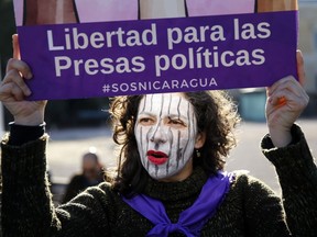 FILE - In this Jan. 12, 2019 file photo, a demonstrator holds a placard reading in Spanish: "Liberty for female political prisoners" during a protest against the Nicaraguan government in Madrid, Spain. The Madres de Abril (Spanish for Mothers of April) group is gearing up for a potentially years-long fight against the government of Nicaraguan President Daniel Ortega in its quest for accountability and justice for the hundreds of people killed in the government suppression of protests since April 2018.