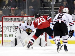 New Jersey Devils center Blake Coleman (20) skates toward Chicago Blackhawks goaltender Cam Ward (30) before scoring a goal during the first period of an NHL hockey game, Monday, Jan. 14, 2019, in Newark, N.J. Blackhawks' Duncan Keith (2) looks on during the play.