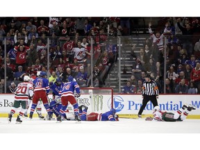 New Jersey Devils left wing Marcus Johansson, right, of Sweden, falls forward while scoring a goal on the New York Rangers during the first period of an NHL hockey game, Thursday, Jan. 31, 2019, in Newark, N.J.