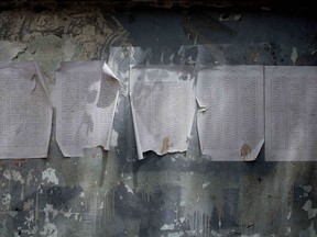 A worn-out list of registered names for aid by Relief International, part of the World Food Program, is posted in Aden, Yemen in this July 23, 2018 photo. The U.N.'s World Food Program has 5,000 distribution sites across the country targeting 10 million people a month with food baskets but says it can monitor only 20 percent of the deliveries. Armed factions on all sides of Yemen conflict are diverting aid for their own purposes, worsening the country's humanitarian crisis, an AP investigation found.