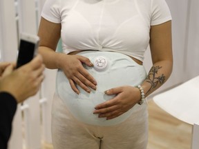 A model wears the Owlet Band pregnancy monitor at the Owlet booth at CES International, Wednesday, Jan. 9, 2019, in Las Vegas. The device can track fetal heart rate, kicks and contractions.