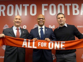 Toronto FC president Bill Manning (left to right), new general manager Ali Curtis and head coach Greg Vanney hold up a team scarf at a news conference introducing Curtis in Toronto, Thursday, Jan.3, 2019.
