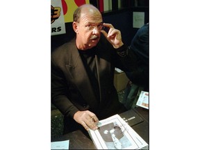 FILE - In this Nov. 13, 1998 file photo, Gene Okerlund announcer for World Championship Wrestling, signs autographs in Philadelphia. Okerlund, who interviewed pro wrestling superstars "Macho Man" Randy Savage, The Ultimate Warrior and Hulk Hogan, has died. He was 76. WWE announced Okerlund's death on its website Wednesday, Jan. 2, 2019.