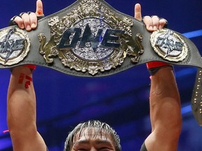 FILE - In this April 21, 2017, file photo, Philippines' Eduard Folayang raises his championship belt during an award ceremony after beating Malaysian-born Ev Ting in the lightweight Mixed Martial Arts title fight dubbed One FC (Fighting Championship), in Pasay city, south of Manila, Philippines. One Championship, the MMA organization out of Asia, is going global in 2019 and it's making the kind of moves that shows it plans to become a player in combat sports.