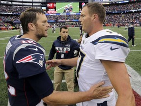 FILE - In this Oct. 29, 2017, file photo, New England Patriots quarterback Tom Brady (12) and Los Angeles Chargers quarterback Philip Rivers (17) speak at midfield after an NFL football game, in Foxborough, Mass. The Chargers and Patriots meet in a divisional playoff game on Sunday, Jan. 13, 2019.