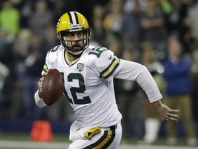 FILE - In this Nov. 15, 2018, file photo, Green Bay Packers quarterback Aaron Rodgers looks to pass against the Seattle Seahawks during the first half of an NFL football game, in Seattle. The Packers play the Minnesota Vikings on Sunday. The NFL's six highest-paid quarterbacks in 2018 will be spectators this postseason. Green Bay's Aaron Rodgers ($33.5 million), Atlanta's Matt Ryan ($30 million), Minnesota's Kirk Cousins ($28 million), San Francisco's Jimmy Garoppolo ($27.5 million), Detroit's Matthew Stafford ($27 million) and Oakland's Derek Carr ($25 million) couldn't lead their teams to the playoffs.