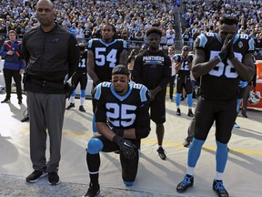 FILE - In this Nov. 25, 2018, file photo, Carolina Panthers' Eric Reid (25) kneels during the national anthem before an NFL football game against the Seattle Seahawks, in Charlotte, N.C. The NFL and the NFL Players Association has released a joint statement saying an independent administrator found Panthers safety Eric Reid received the "normal" number of drug tests this season and he was not the subject of targeting by the league. Reid said in December he had been tested seven times by the NFL. He said the league was targeting him because of the ongoing collusion case against the NFL alleging that team owners conspired to keep him out of the league because of his decision to kneel during the national anthem to protest racial and social injustice.