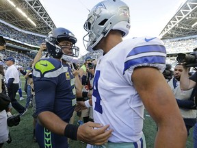 FILE - In this Sept. 23, 2018, file photo, Seattle Seahawks quarterback Russell Wilson, left, greets Dallas Cowboys quarterback Dak Prescott, right, following an NFL football game in Seattle. Russell Wilson won a playoff game with Seattle as a rookie, a Super Bowl in his second season and another NFC championship the third time around. The best Dak Prescott can hope for with the Dallas Cowboys is to join Wilson on that list of Super Bowl winners in his third year, a quest that will start with the first postseason meeting of quarterbacks with quite a bit in common, other than postseason pedigree.