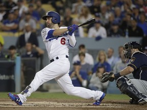 FILE - In this Oct. 16, 2018, file photo, Los Angeles Dodgers' Brian Dozier hits an RBI single during the first inning of Game 4 of the National League Championship Series baseball game against the Milwaukee Brewers, in Los Angeles. A person familiar with the negotiations tells The Associated Press that free-agent second baseman Brian Dozier and the Washington Nationals have agreed to a $9 million, one-year contract, subject to the successful completion of a physical exam.  The person confirmed the deal on condition of anonymity Thursday, Jan. 10, 2019, because neither the club nor player had announced anything.
