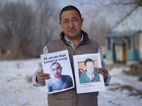 In this Dec. 8, 2018, photo, Adilgazy Yergazy, a farmer, holds up pictures of his detained younger brothers at his home in a village near Almaty, Kazakhstan. The Kazakhstan Foreign Ministry says China is allowing more than 2,000 ethnic Kazakhs to abandon their Chinese citizenship and leave the country, a sign that Beijing may be starting to feel a mounting backlash against a sweeping crackdown on Muslims in its far west region of Xinjiang. Yergazy says two of his little brothers were arrested and taken to internment camps last year, and that one was recently released from the camps but is unable to leave China.