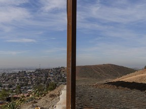 FILE - This Saturday, Dec. 22, 2018 file photo shows Tijuana, Mexico, left, and San Diego, Calif., separated by a U.S. border fence. The partial government shutdown which started in December 2018 has furloughed hundreds of thousands of government employees and halted services that aren't deemed essential, including, in many instances, the immigration courts overseen by the Justice Department.