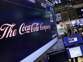 FILE - In this Friday, Dec. 9, 2016 file photo, the Coca-Cola logo appears above the post where it trades on the floor of the New York Stock Exchange. With obesity becoming a more pressing global problem, two January 2109 reports in science journals are calling for policies that limit industry influence and reviving debate about what role food companies should play in public health efforts.