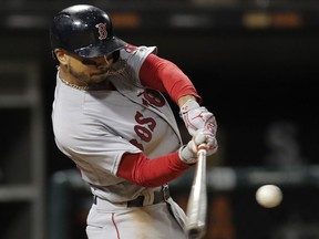FILE - In this Thursday, Aug. 30, 2018, file photo, Boston Red Sox's Mookie Betts hits a two-run home run against the Chicago White Sox during the seventh inning of a baseball game in Chicago. Betts and the World Series champion Red Sox agreed to a $20 million, one-year contract on Friday, a $9.5 million raise for an arbitration-eligible player that topped pitcher Max Scherzer's $8.8 million raise from Detroit in 2014.