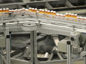 FILE - In this July 10, 2018 file photo, bottles of prescription medicines ride on a conveyor belt at a pharmacy warehouse in Florence, N.J. According to a report released on Tuesday, Jan. 8, 2018, annual spending by the U.S. health industry on ads and promotions has reached $30 billion. That includes advertisements for prescription drugs that were shown 5 million times on TV and elsewhere in 2016. That's a huge increase in 20 years and just part of broad health industry efforts to promote drugs, devices, lab tests and even new hospitals.