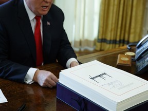 FILE- In this Dec. 22, 2017, file photo President Donald Trump speaks with reporters after signing the tax bill and continuing resolution to fund the government in the Oval Office of the White House in Washington. Millions of small business owners and their tax advisers will be in uncharted waters as they tackle 2018 returns, a new deduction that can exempt one-fifth of owners' business income but that is complex and confusing.